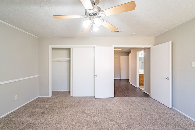 unfurnished bedroom featuring carpet floors, a closet, visible vents, ceiling fan, and a textured ceiling