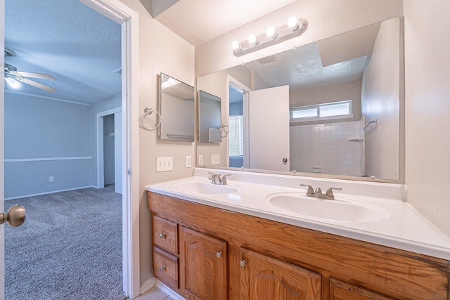 bathroom featuring a textured ceiling, double vanity, and a sink