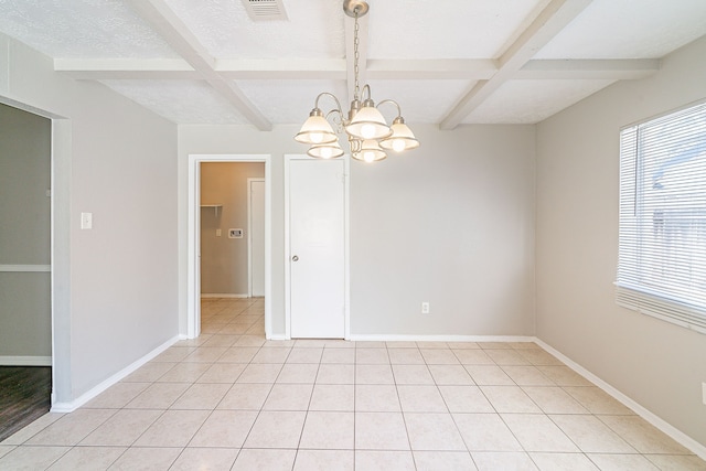 unfurnished room with a textured ceiling, beamed ceiling, and baseboards