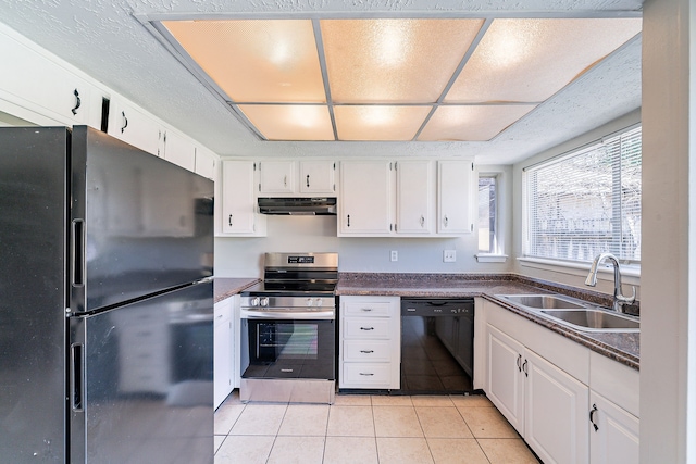 kitchen with light tile patterned floors, under cabinet range hood, a sink, black appliances, and dark countertops