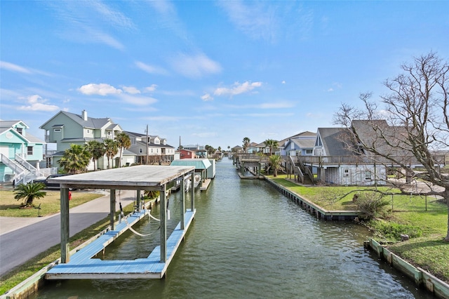 view of dock with a water view, boat lift, and a residential view