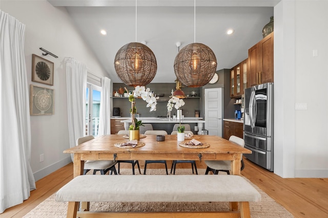 dining space with high vaulted ceiling, light wood-type flooring, and recessed lighting