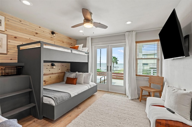 bedroom featuring access to outside, wood walls, light wood-type flooring, and recessed lighting