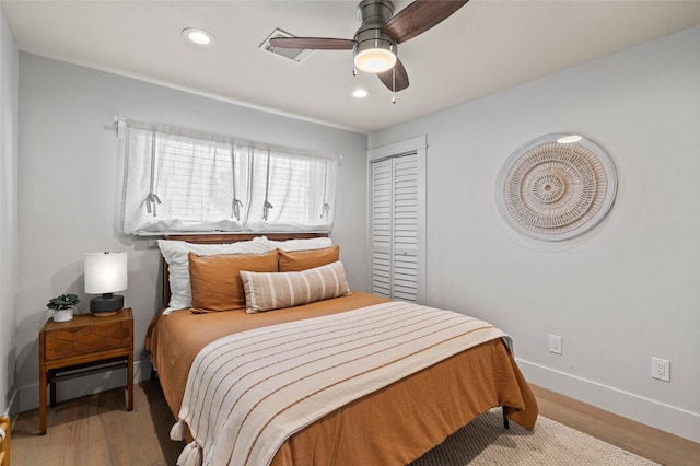 bedroom with baseboards, ceiling fan, wood finished floors, a closet, and recessed lighting