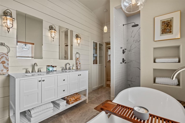 bathroom with a freestanding tub, a sink, a marble finish shower, and double vanity