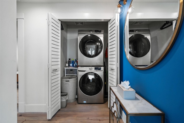 laundry area featuring laundry area, stacked washer and clothes dryer, and wood finished floors