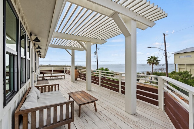 wooden deck featuring a water view and a pergola