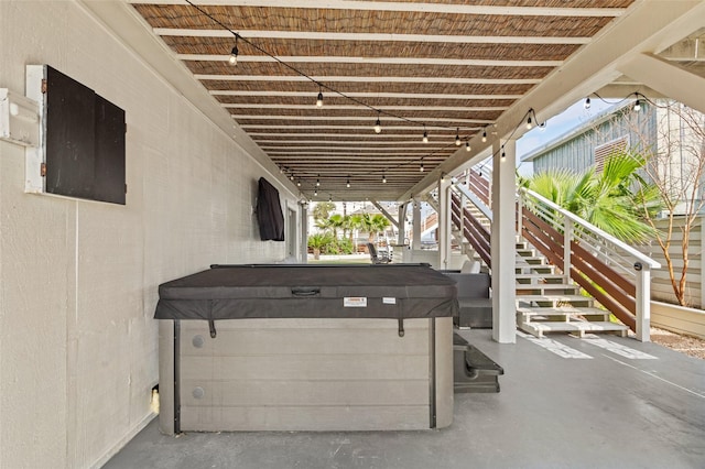 view of patio with stairway and a hot tub