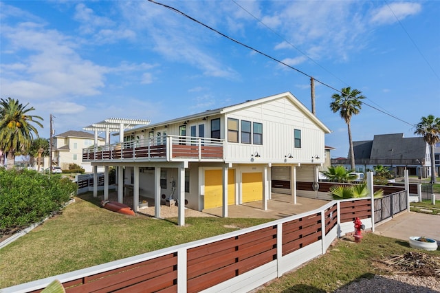 rear view of property featuring board and batten siding, a patio area, and a lawn