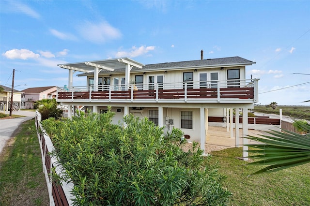 back of property with a deck and a pergola