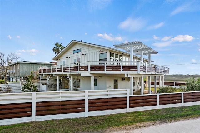 view of front of home featuring fence, a wooden deck, and a pergola