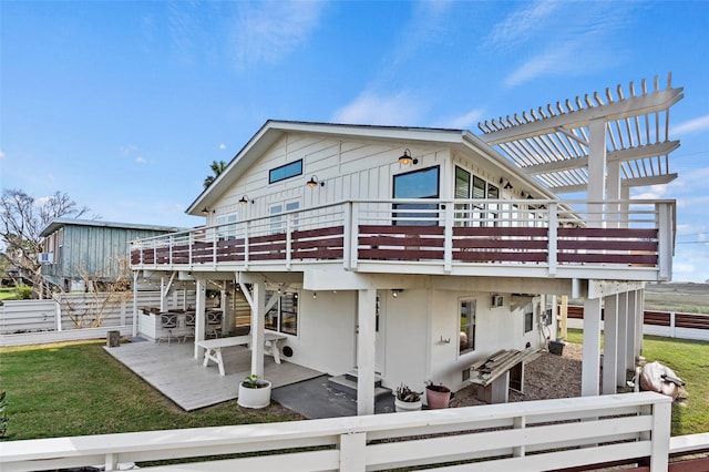 back of house featuring a deck, fence, a pergola, board and batten siding, and a patio area