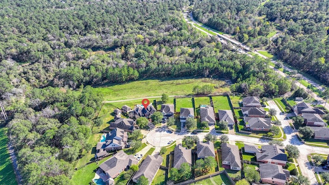 birds eye view of property featuring a residential view and a wooded view