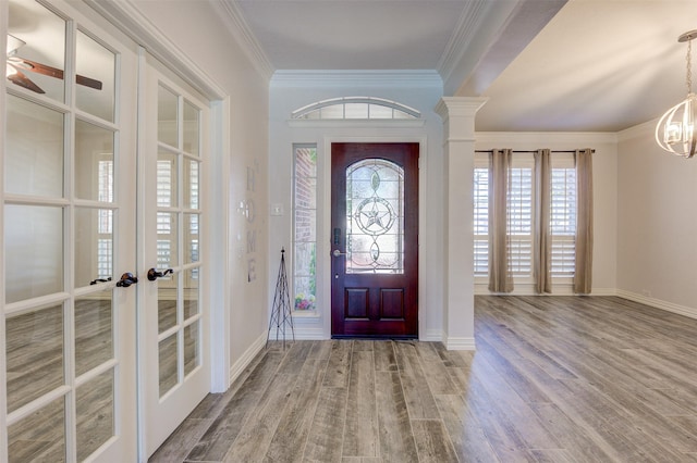 foyer featuring crown molding, baseboards, wood finished floors, and french doors