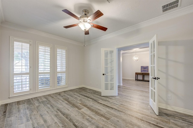 unfurnished room featuring light wood-style floors, visible vents, crown molding, and french doors