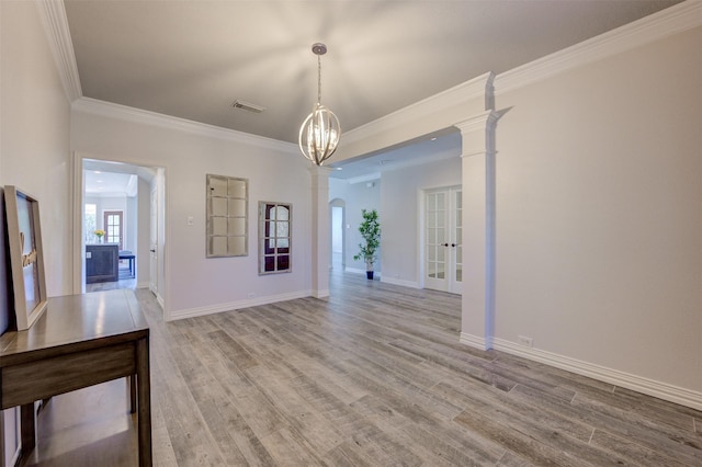 unfurnished dining area featuring crown molding, light wood finished floors, visible vents, and baseboards