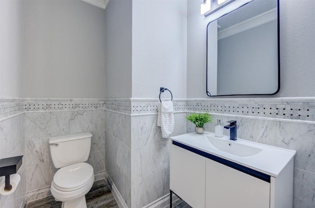 bathroom with toilet, a wainscoted wall, wood finished floors, and vanity