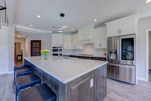 kitchen with light wood finished floors, tasteful backsplash, white cabinetry, and stainless steel appliances