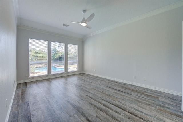 spare room with baseboards, visible vents, ceiling fan, wood finished floors, and crown molding