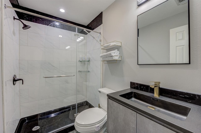 bathroom featuring vanity, a shower stall, and toilet