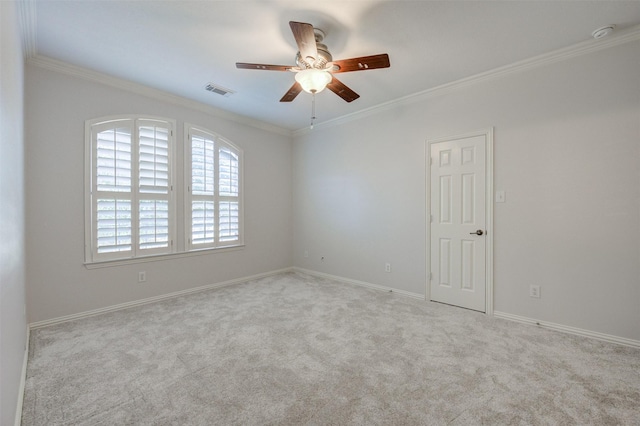 empty room featuring carpet, crown molding, baseboards, and ceiling fan