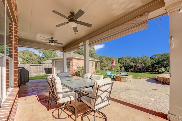 view of patio with an outbuilding, ceiling fan, outdoor dining area, fence, and grilling area