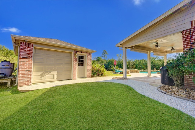 view of yard featuring an outbuilding, a ceiling fan, and an outdoor pool