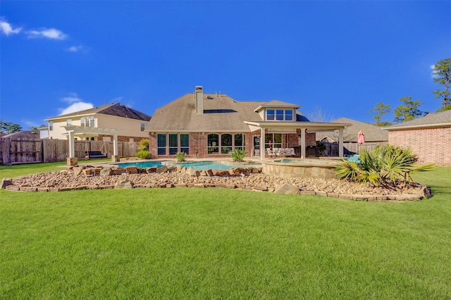 back of house with a fenced in pool, a patio, a fenced backyard, a yard, and brick siding