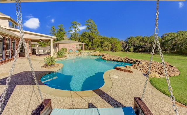 outdoor pool featuring an outbuilding, a lawn, a patio area, and fence