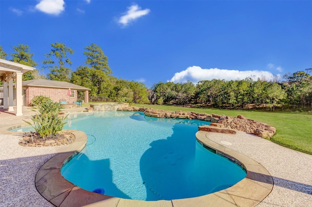 outdoor pool with a lawn and a patio