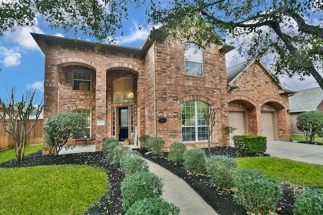 view of front of house featuring a garage, fence, brick siding, and driveway