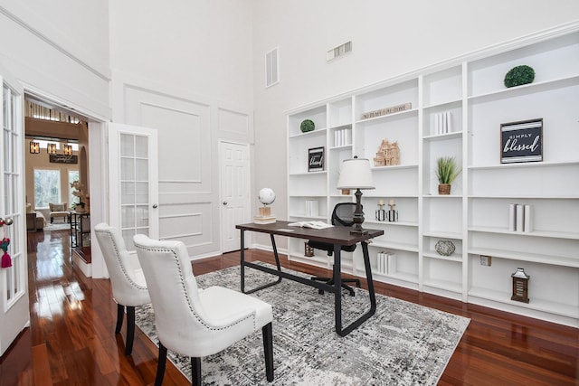 home office with visible vents, a high ceiling, and dark wood-style flooring