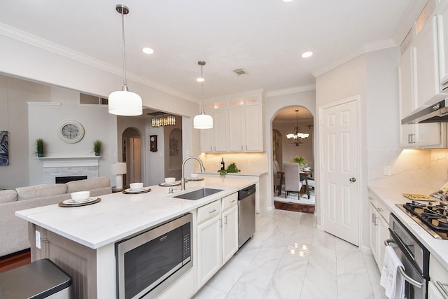 kitchen featuring a sink, decorative backsplash, arched walkways, and appliances with stainless steel finishes