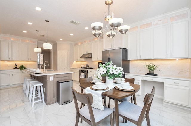 kitchen with under cabinet range hood, visible vents, marble finish floor, and appliances with stainless steel finishes