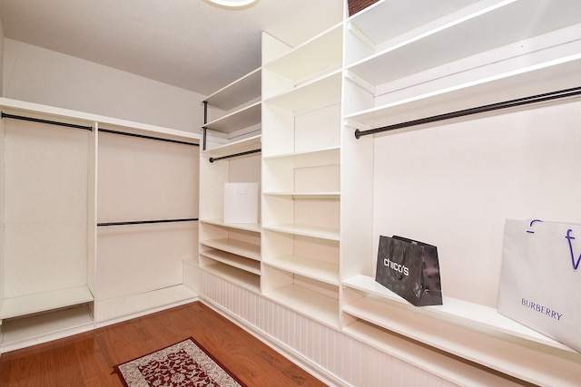 walk in closet with wood finished floors