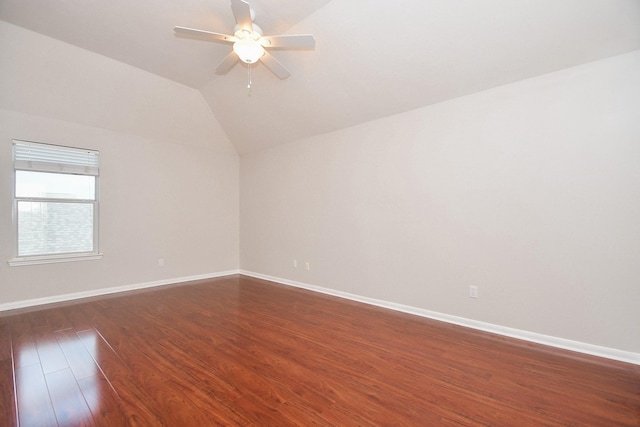 unfurnished room featuring vaulted ceiling, baseboards, dark wood-style flooring, and ceiling fan