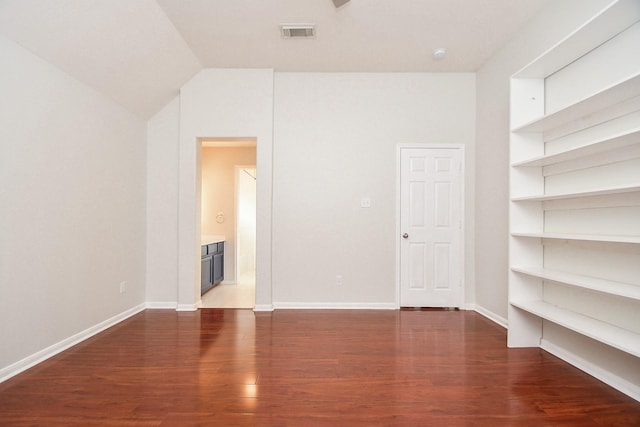 interior space featuring built in shelves, wood finished floors, visible vents, and baseboards