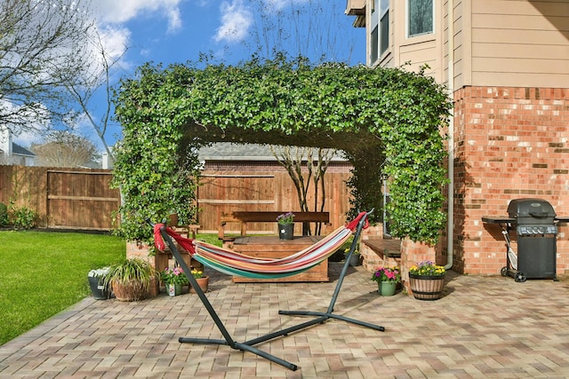 view of playground featuring a patio, fence, and a lawn