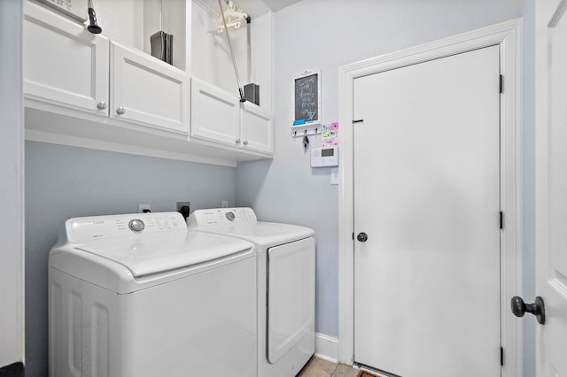 laundry room with washing machine and dryer, cabinet space, and baseboards