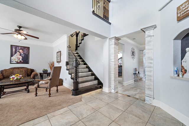 foyer featuring ceiling fan, stairs, tile patterned floors, decorative columns, and crown molding