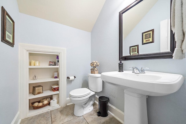 bathroom featuring baseboards, built in features, toilet, tile patterned floors, and a sink