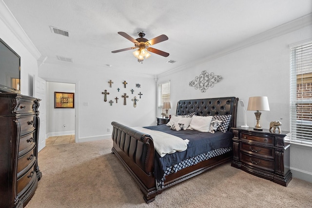 bedroom featuring light colored carpet, visible vents, crown molding, and baseboards