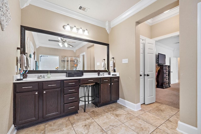 full bathroom with visible vents, baseboards, double vanity, a stall shower, and crown molding