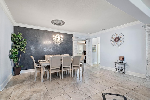 dining area featuring decorative columns, baseboards, an accent wall, ornamental molding, and a notable chandelier