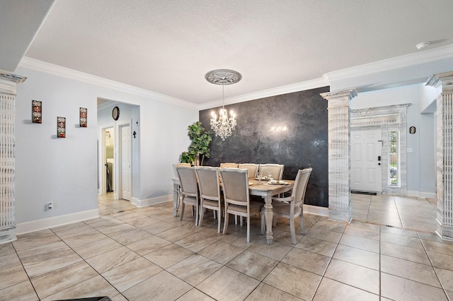 dining room with ornate columns, an accent wall, baseboards, and crown molding