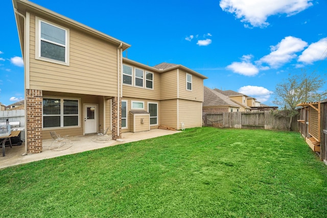 back of house with a patio area, a lawn, a fenced backyard, and brick siding