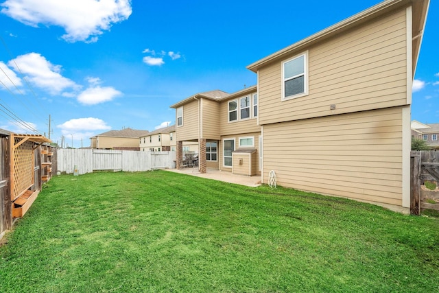 rear view of house with a yard, a patio area, and a fenced backyard