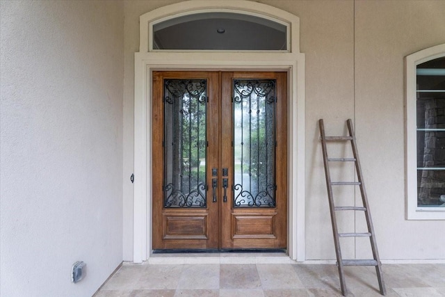 entrance to property with stucco siding and french doors