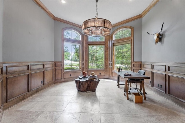 dining space featuring a decorative wall, a notable chandelier, wainscoting, and crown molding