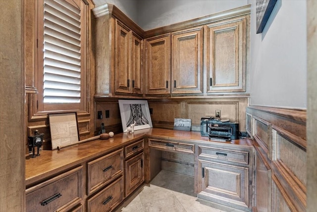 office featuring light tile patterned floors and a wainscoted wall